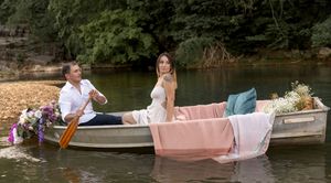 Scenic lake view with decorated boat featuring romantic floral arrangements.