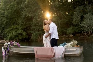 Romantic boat scene with floral decorations and pink textiles at sunset.