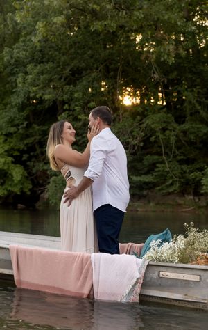 Romantic photoshoot on a decorated boat with pink blankets and white flowers.