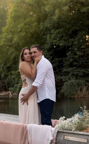 Sunset engagement photoshoot on a decorated boat by a peaceful lake.