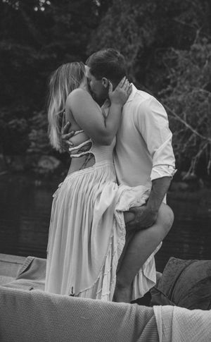 Black and white romantic moment captured on a boat during a sunset photoshoot.
