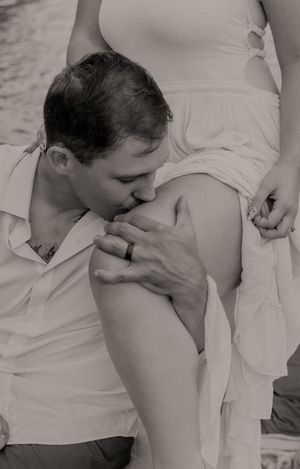 Intimate black and white photograph of a couple sharing a tender moment in a boat.