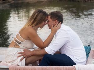 Intimate couple's photoshoot by scenic waterfront setting.