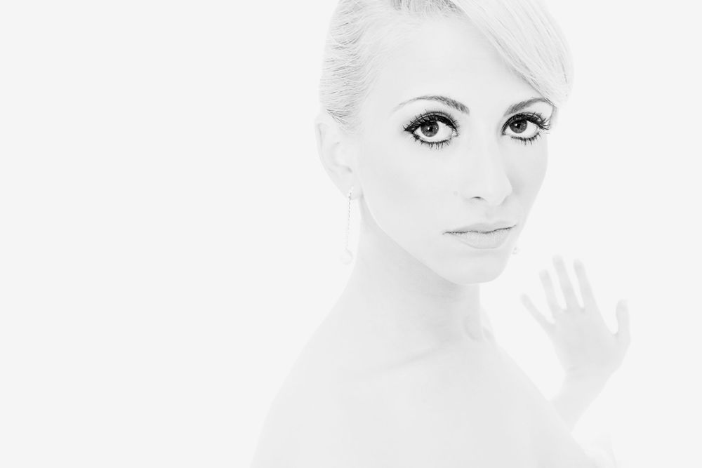 A high-key black and white portrait series showing ethereal beauty with soft lighting and minimalist composition.