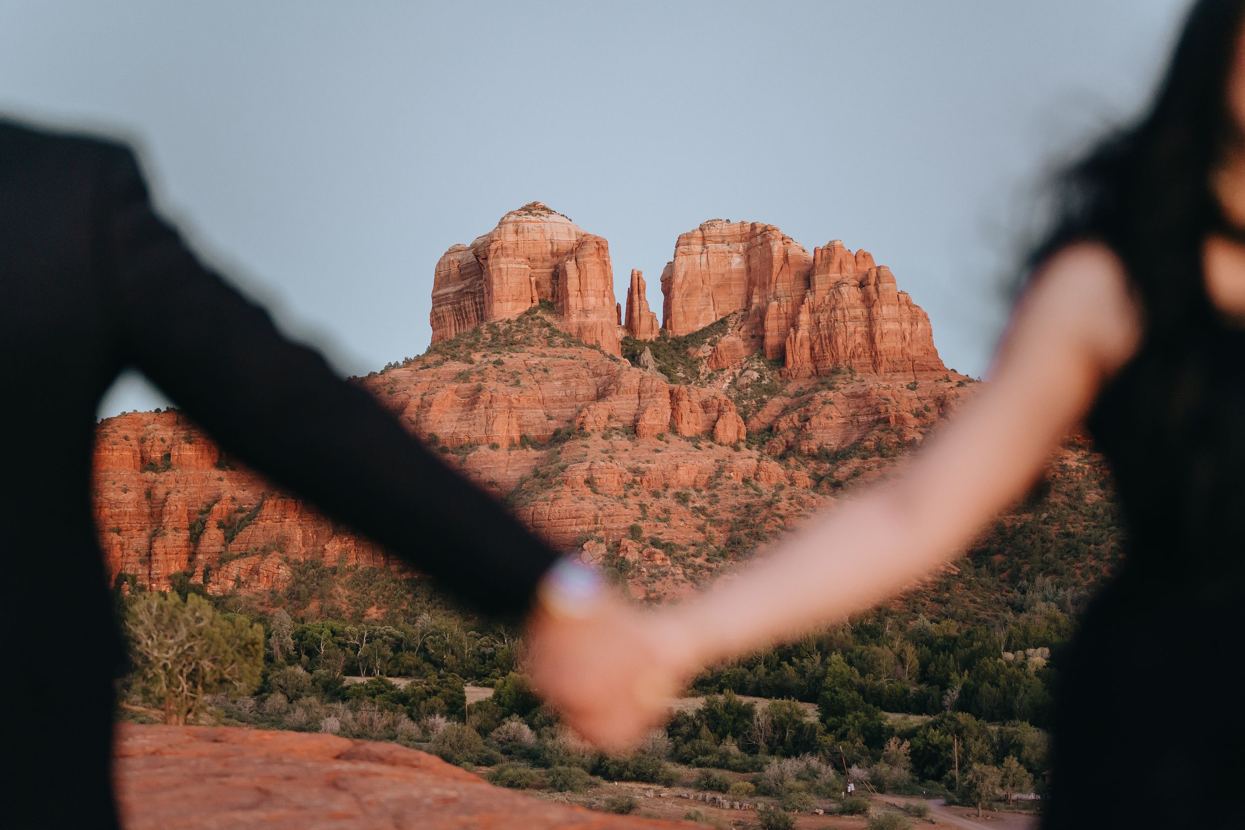 Stunning red rock formations in Sedona at sunset with silhouettes in foreground.