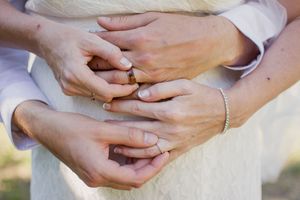 Close-up shots of hands exchanging wedding rings during the ceremony.