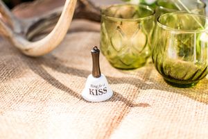 Green glass bottles and burlap fabric create a rustic table setting with natural lighting.