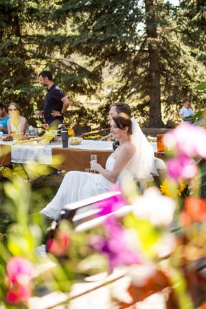 Garden wedding reception tables with vibrant pink flowers in the foreground.