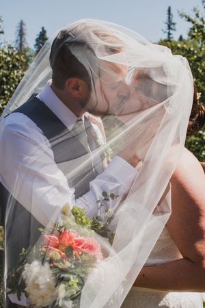 Series of romantic wedding photos showing couple embracing under flowing white veil.