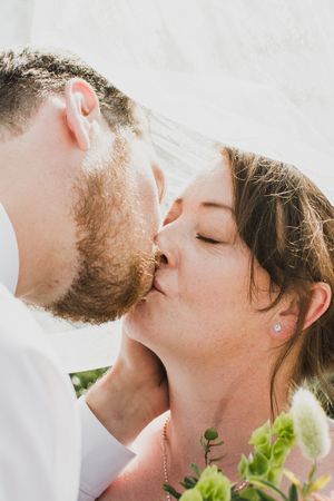 A romantic close-up series of a couple sharing intimate kisses outdoors in natural lighting.