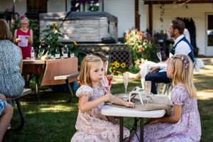 Guests seated at outdoor tables during a summer wedding celebration.
