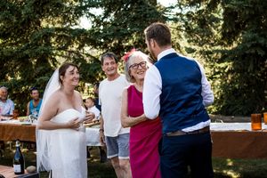 Candid moments captured at an outdoor wedding reception with guests mingling and dancing in a garden setting.