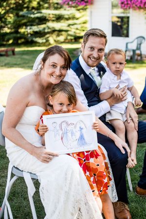 A sweet moment during a wedding celebration as children share artwork on the lawn.