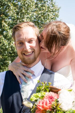 A series of intimate wedding photos showing a couple sharing tender moments outdoors with pink flowers and greenery.