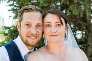 Wedding couple shares intimate moments in outdoor garden setting.