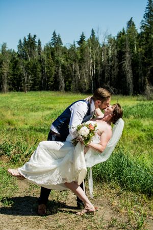 Sequence showing romantic wedding dip kiss in a scenic meadow with evergreen forest backdrop.
