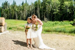 Wedding party walks along a gravel path surrounded by greenery.