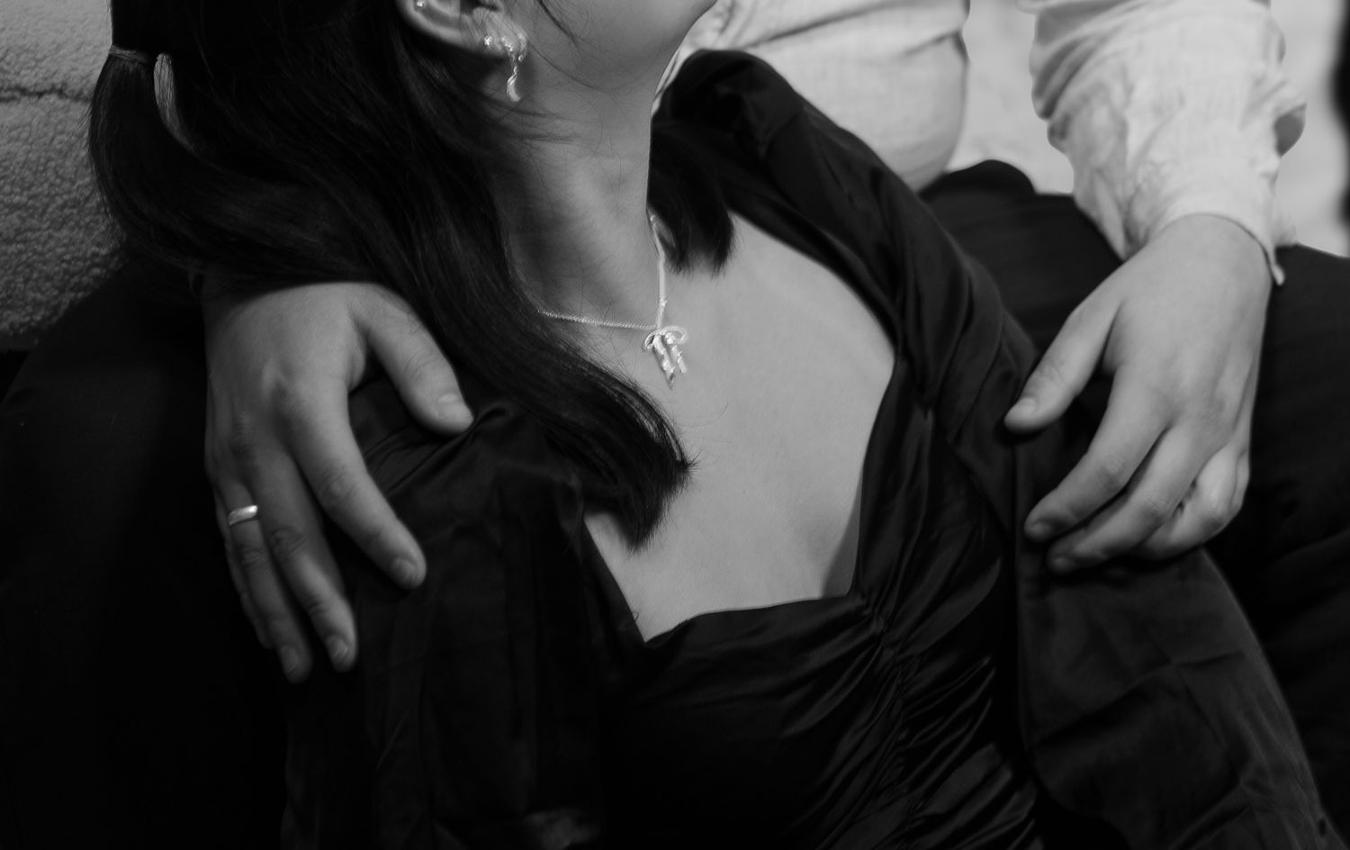 Abstract black and white composition showing cropped body parts in dramatic lighting.