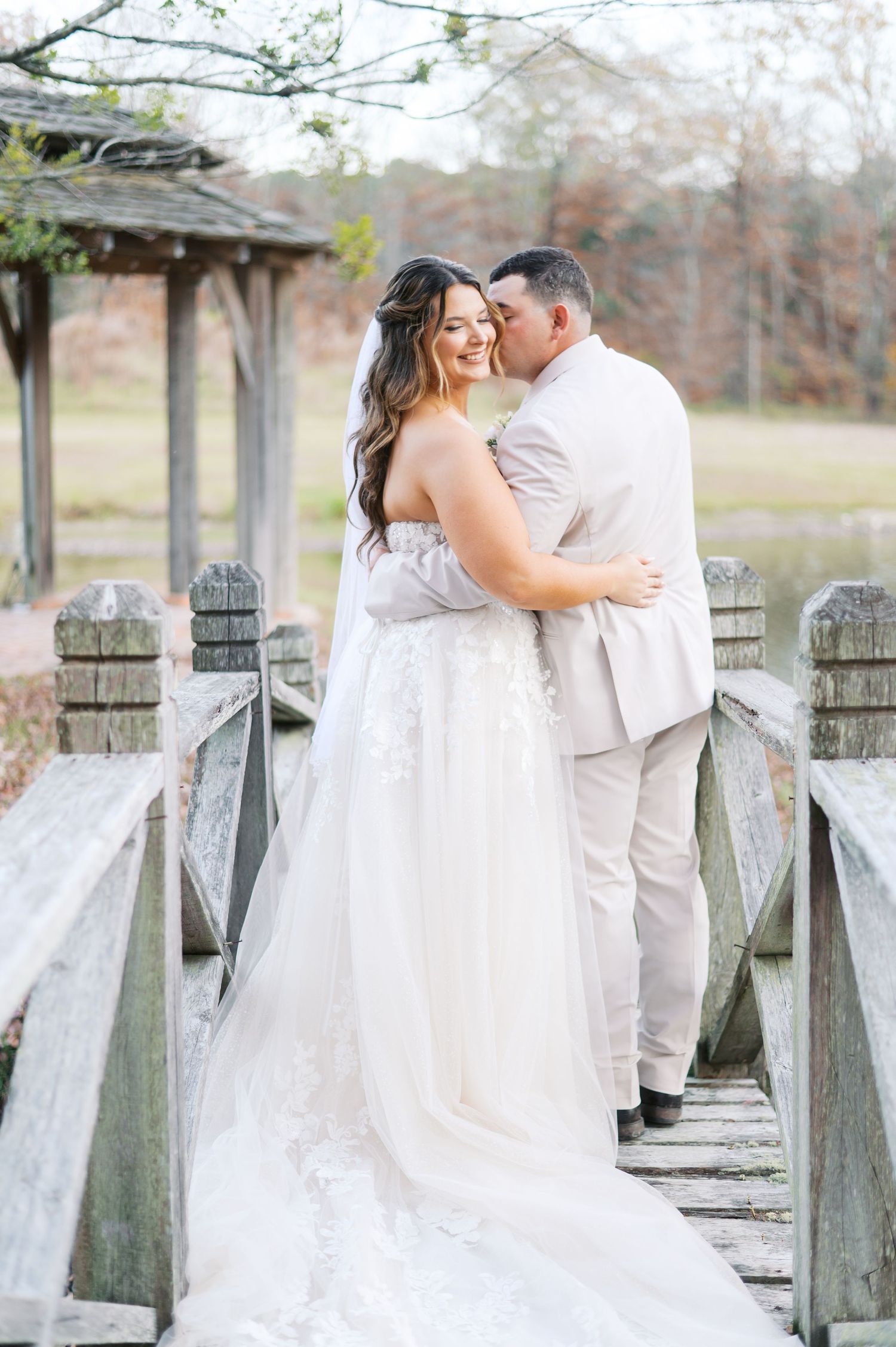 Romantic wedding portraits against a weathered wooden fence showcase tender moments between newlyweds.
