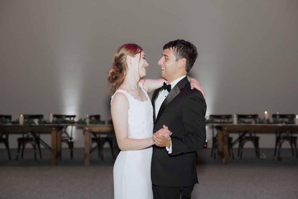 A bride and groom share their first dance together in an elegant reception hall.