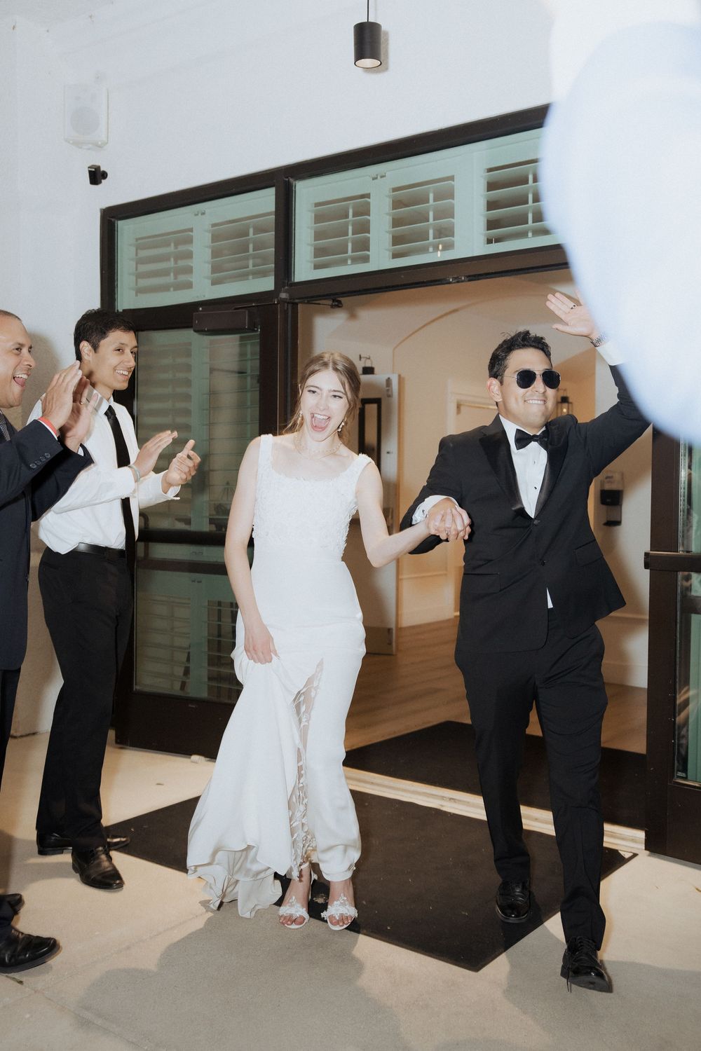 A couple in wedding attire dances playfully in a sequence of candid photos showing their fun dance moves.