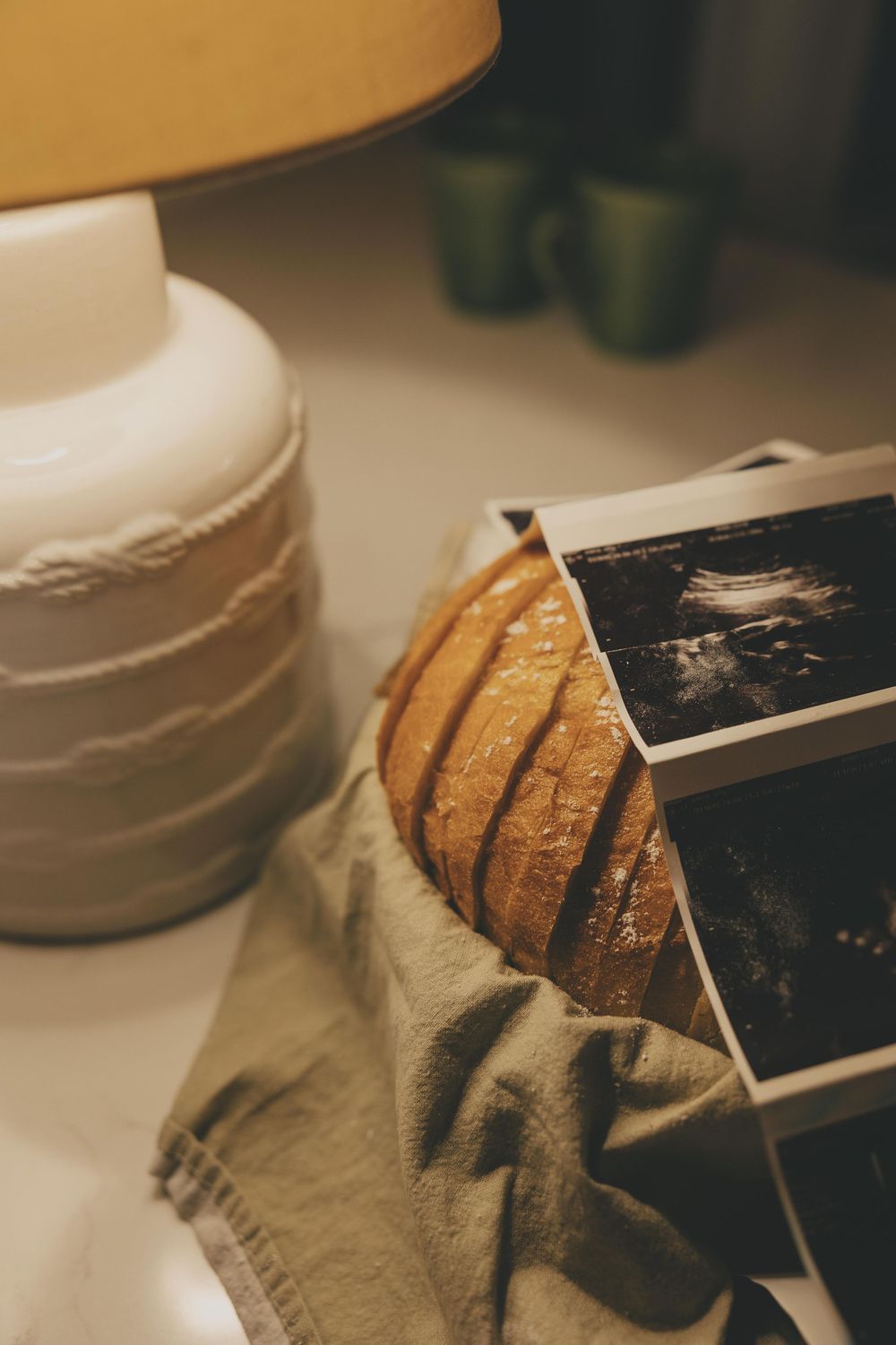 A close-up sequence showing a knife slicing through a loaf of crusty artisanal bread on a cloth surface.