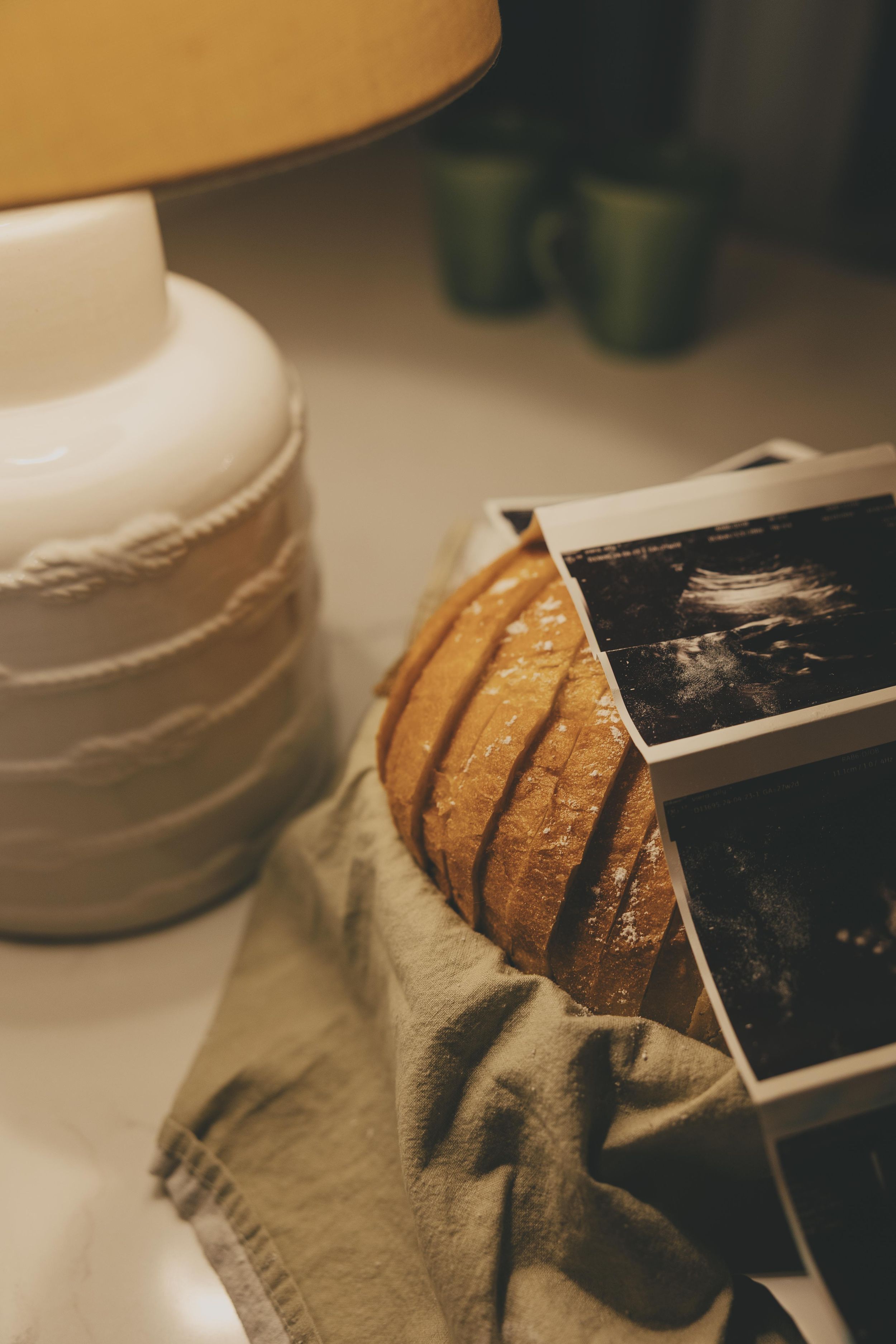 A close-up sequence showing a knife slicing through a loaf of crusty artisanal bread on a cloth surface.