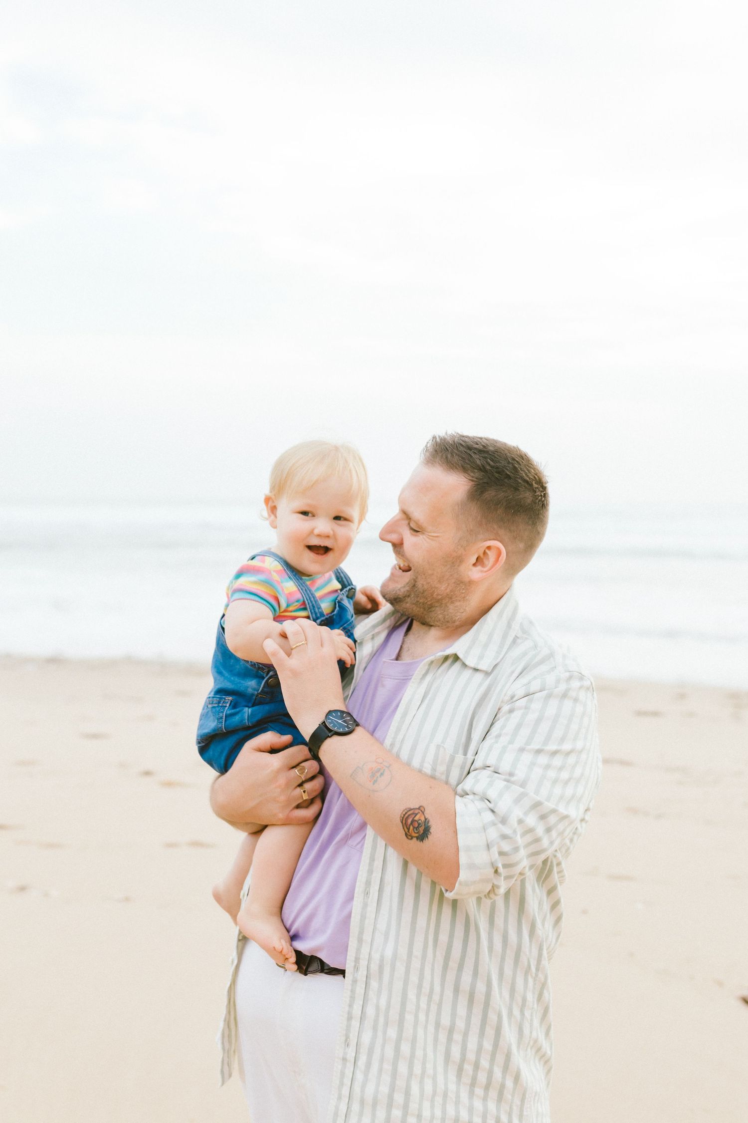 A joyful moment shared between parent and baby playing together on a sunny beach.
