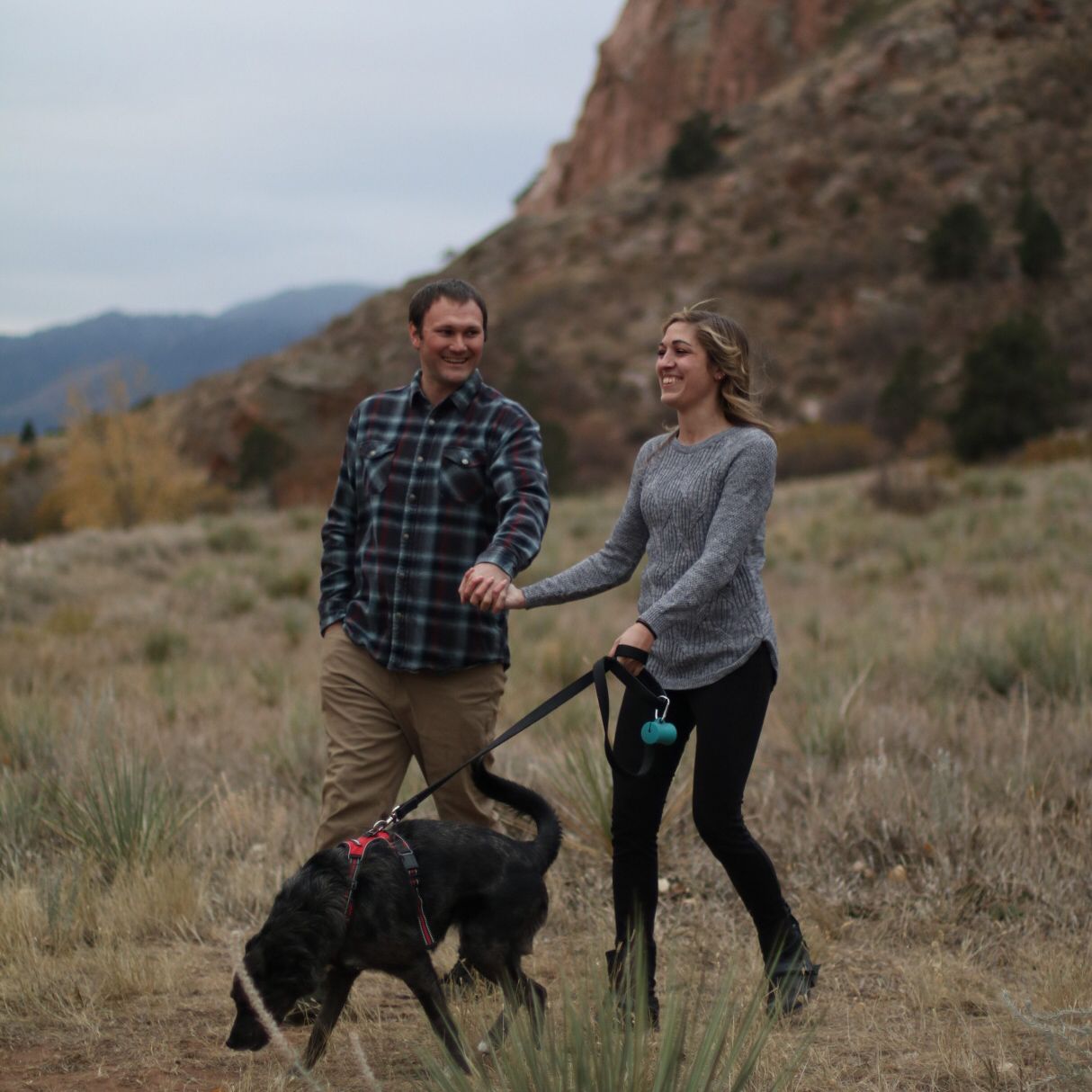 happy couple walking a dog