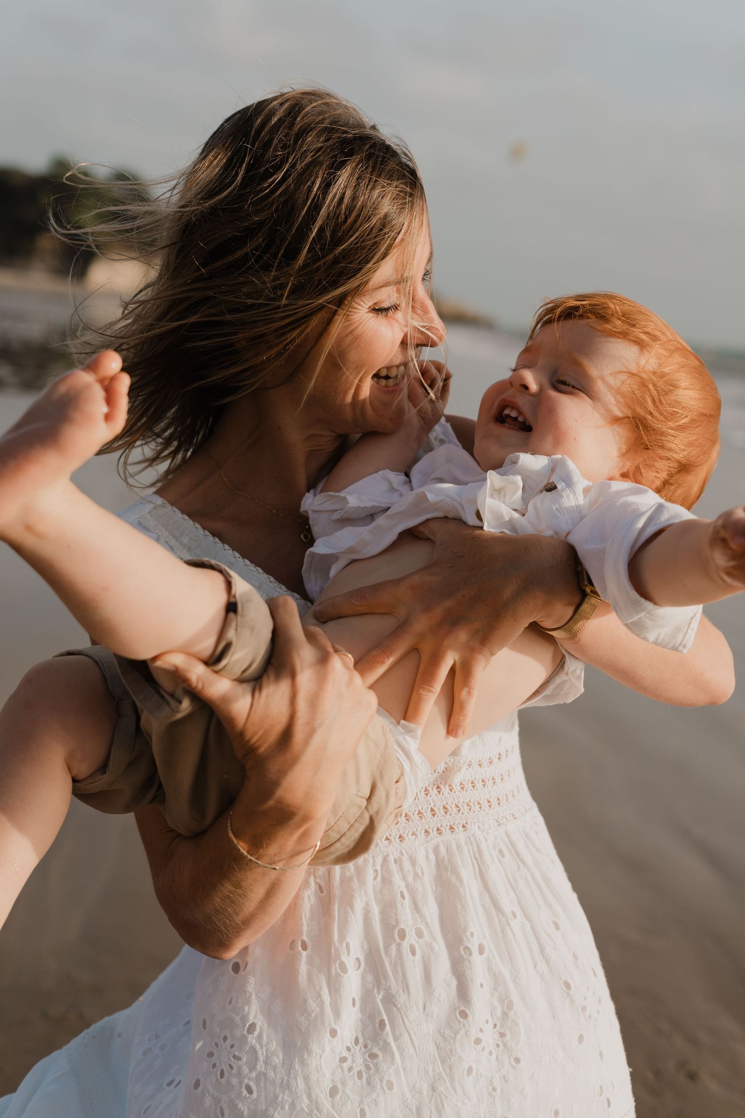 Photo d'un câlin entre une mère et son fils, sur la plage.