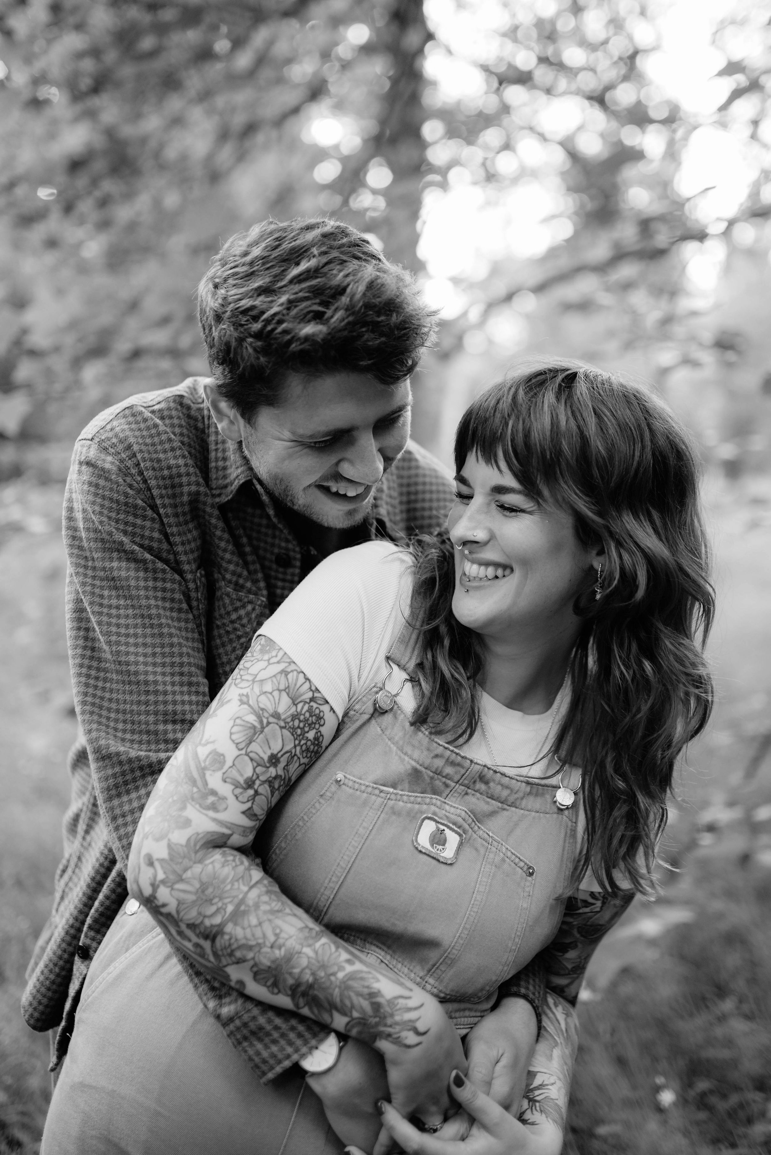 A romantic couple shares tender moments in a series of black and white photos outdoors.