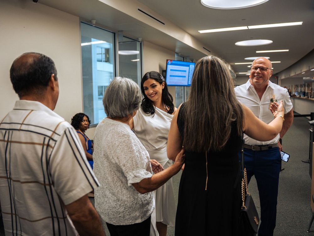 Healthcare professionals and visitors having a conversation in a modern hospital hallway with circular ceiling lights in Naples, Florida