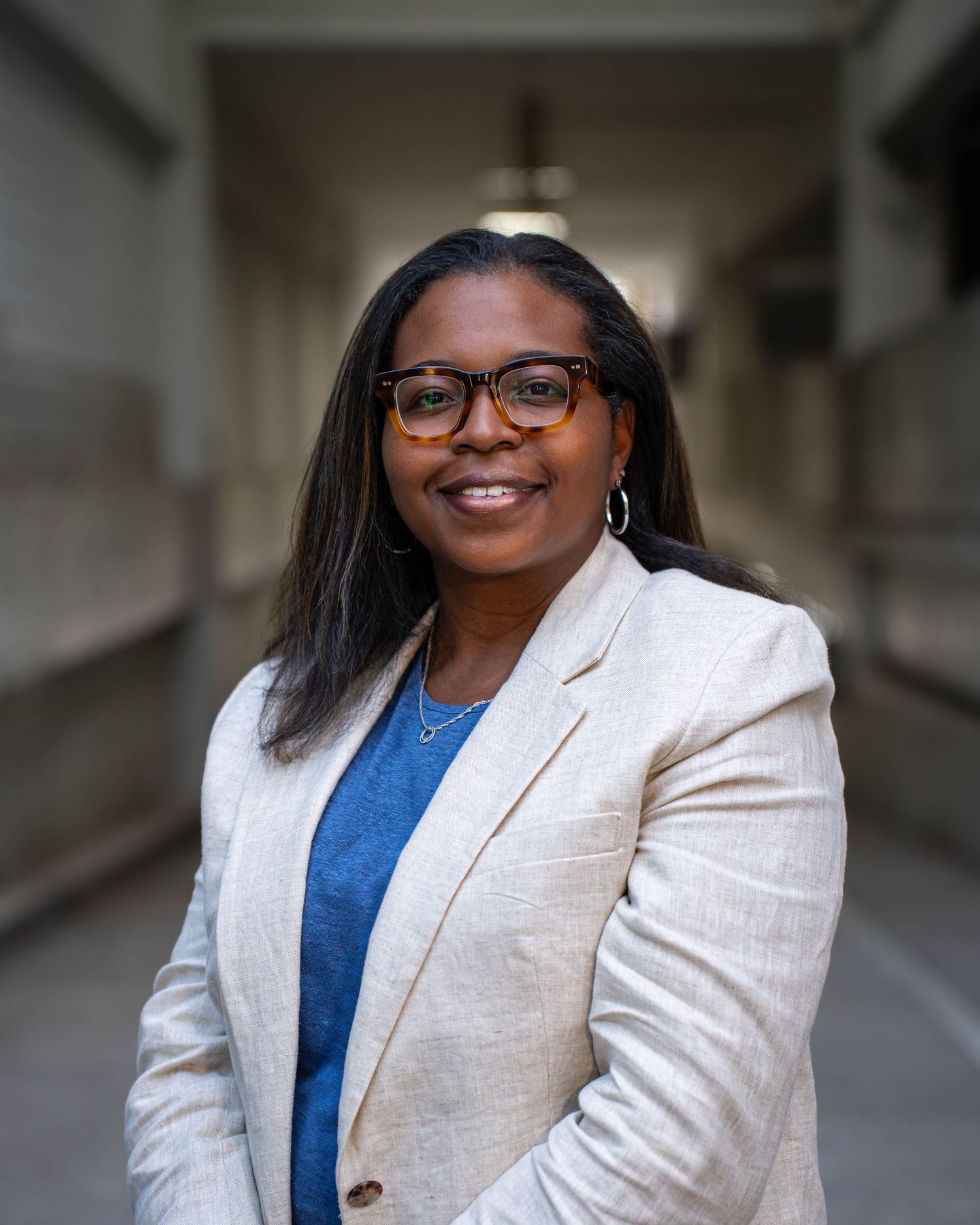 Professional wearing a white blazer and blue top poses for a series of headshots with varying expressions.