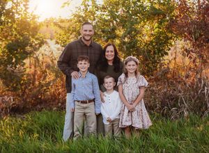Family portrait with golden sunset light in natural outdoor setting.