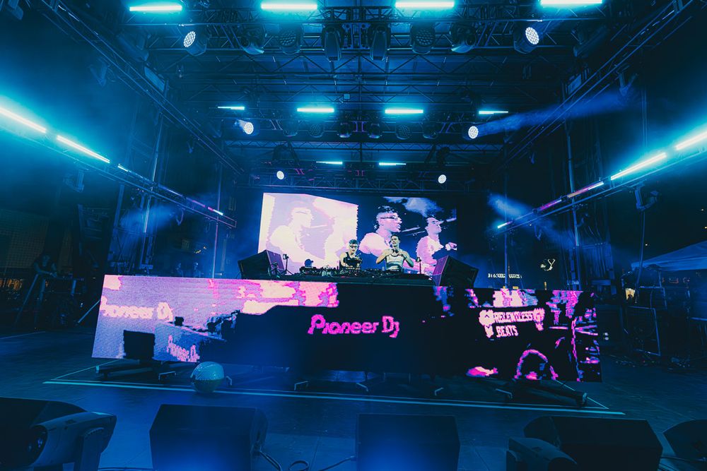 Concert stage illuminated with vibrant blue lighting and spotlights creating a dramatic atmosphere during a live performance.