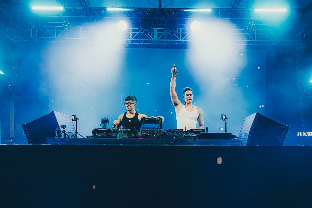 Stage setup bathed in ethereal blue lights and white spotlights creating an atmospheric concert environment.