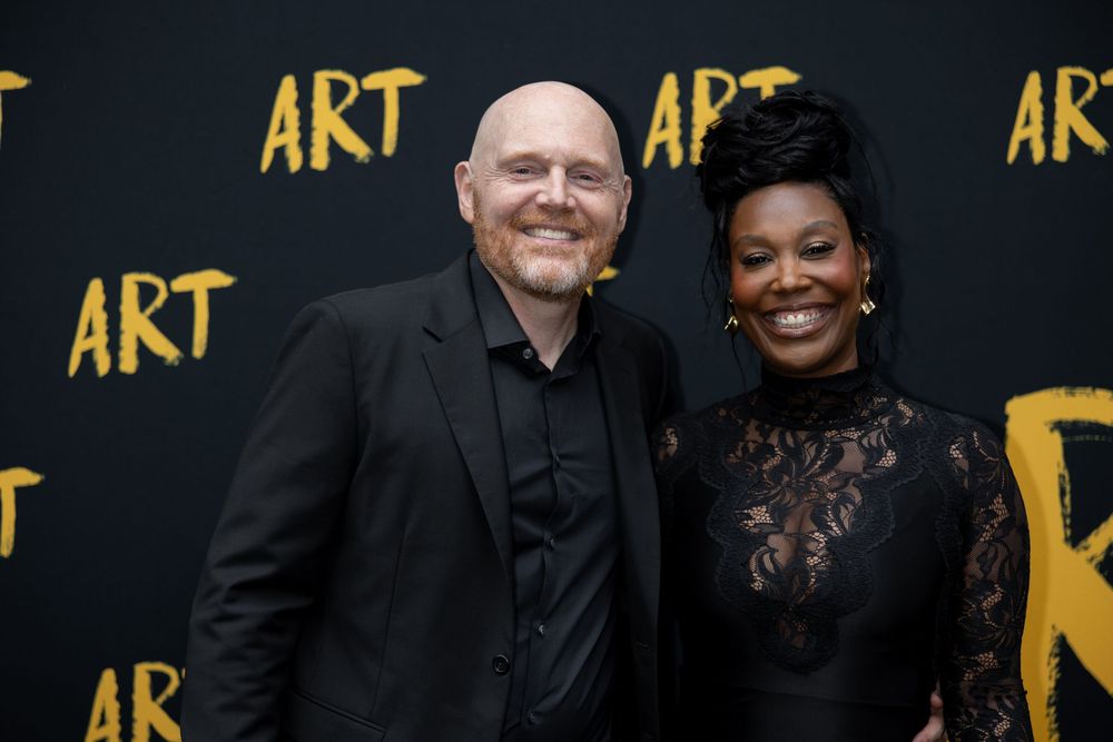 A group of people pose together at an event with gold 'ART' text visible on a black backdrop.