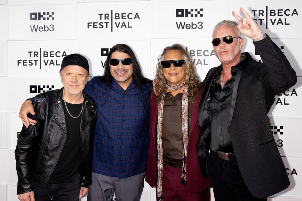 A group poses together at the Tribeca Film Festival red carpet event wearing casual and formal attire.