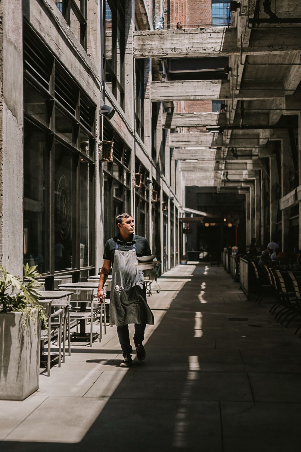 Industrial style covered walkway with dramatic shadows and columns.