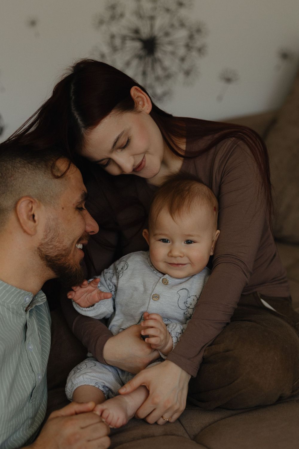 A family shares tender moments with their baby in a series of intimate photographs with warm lighting.