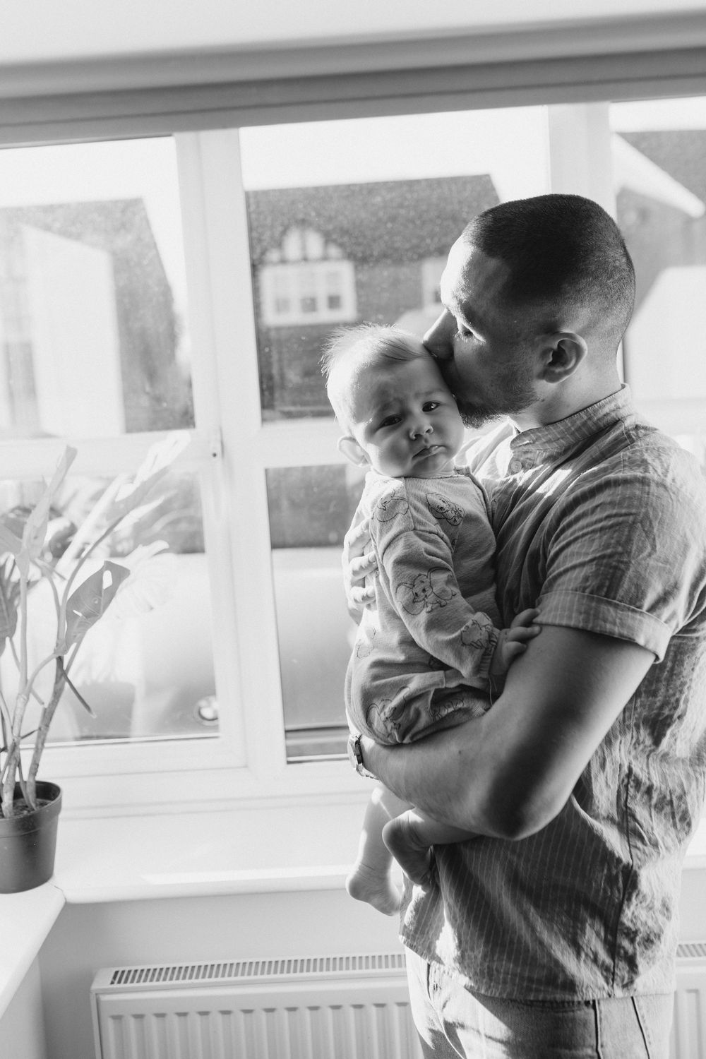 A series of tender moments captured in black and white showing a parent holding and comforting a small baby.