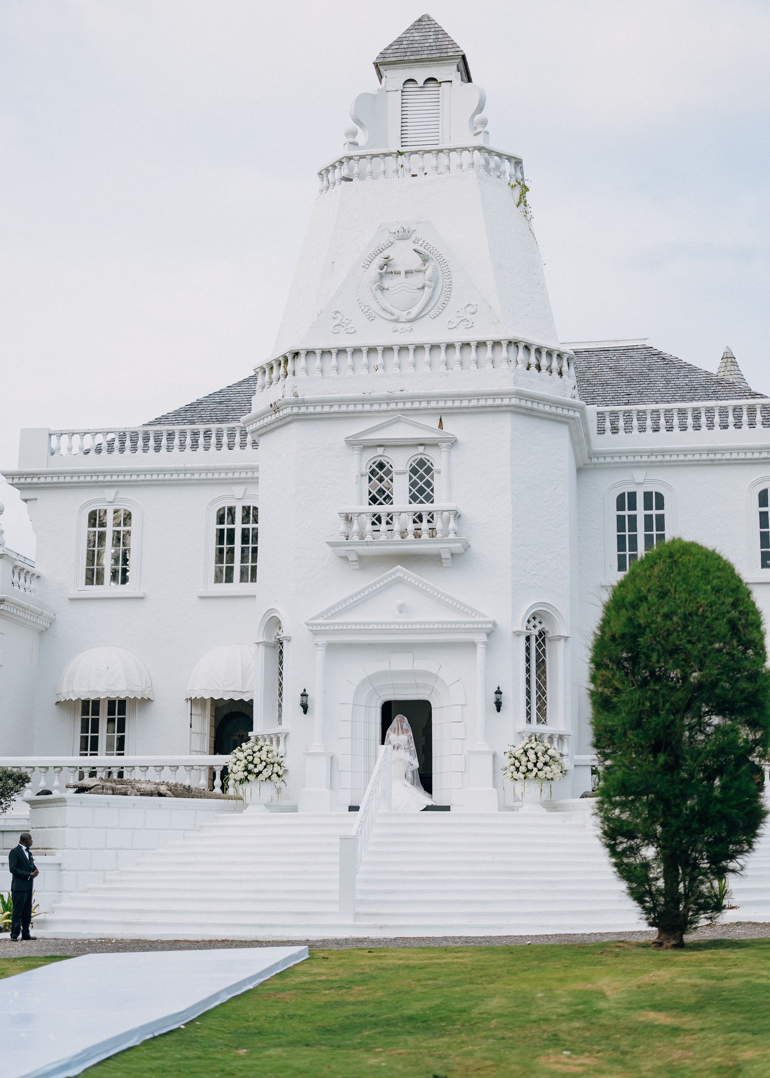 A panoramic view of a pristine white church with Greek Revival architecture and manicured lawns in front.