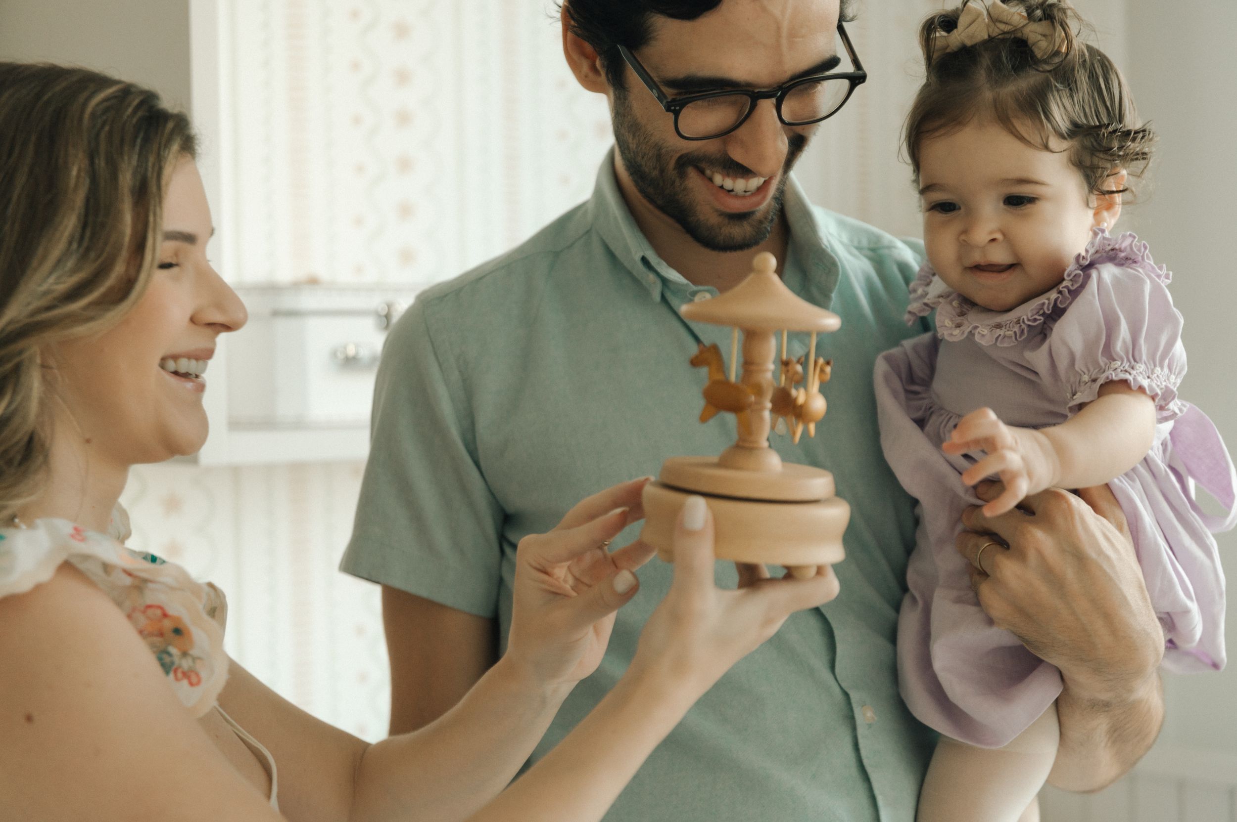 Family sharing a joyful moment while holding a birthday cake together.