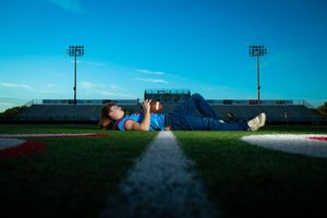 Inflatable decorations line a sports field at dusk with stadium lights glowing against a deep blue sky.