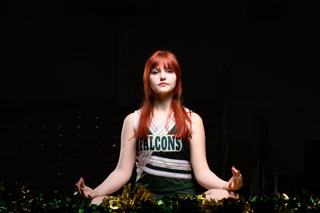 Athlete in Falcons jersey meditates in lotus pose against dark background.