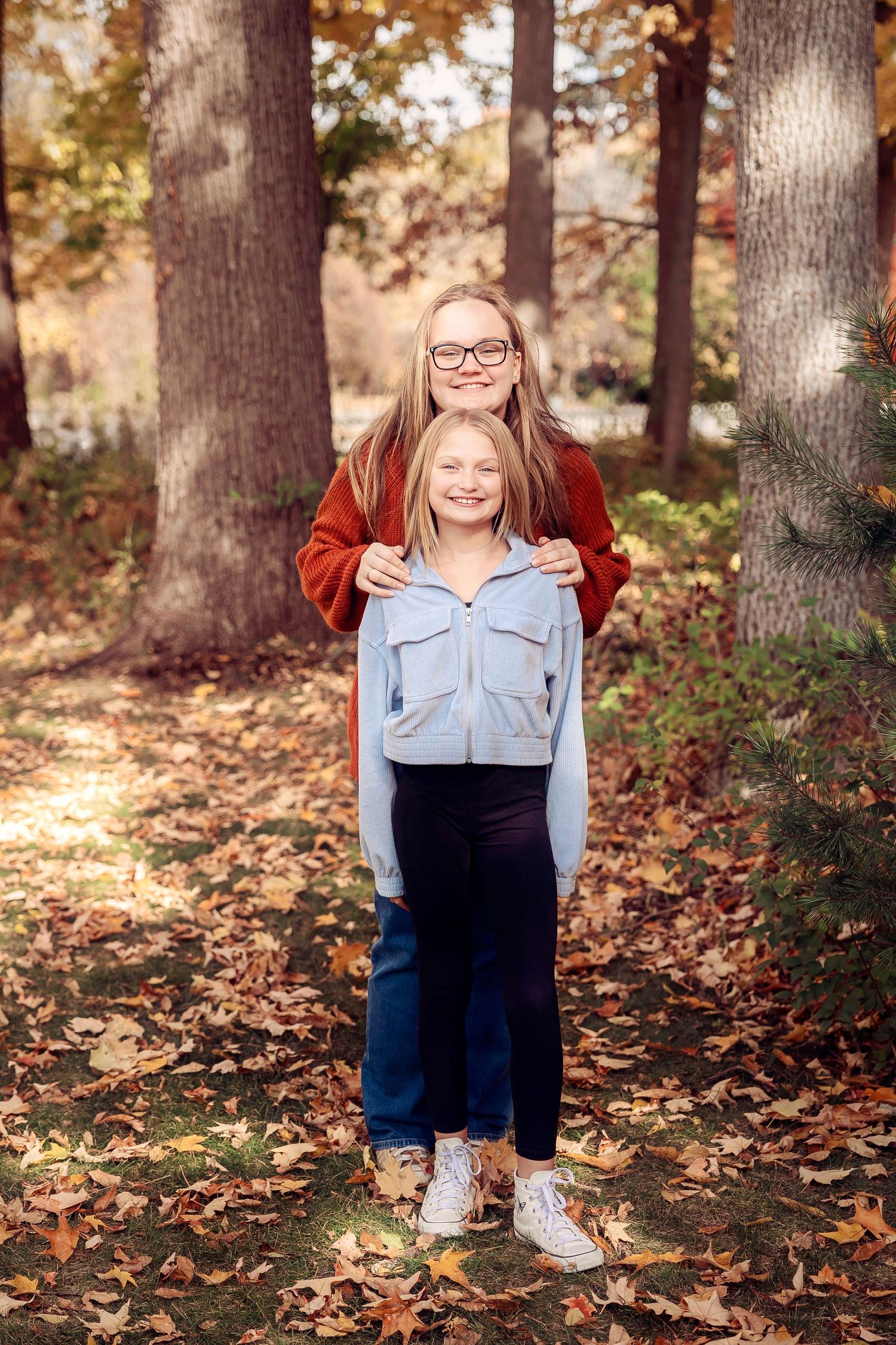 Two people pose together among fall foliage and trees wearing casual sweaters- Michigan Detroit Novi Northville Portrait Photographer