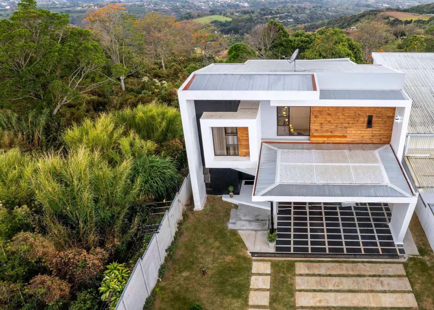 Aerial view of a modern two-story home surrounded by lush greenery in Atenas, Costa Rica.