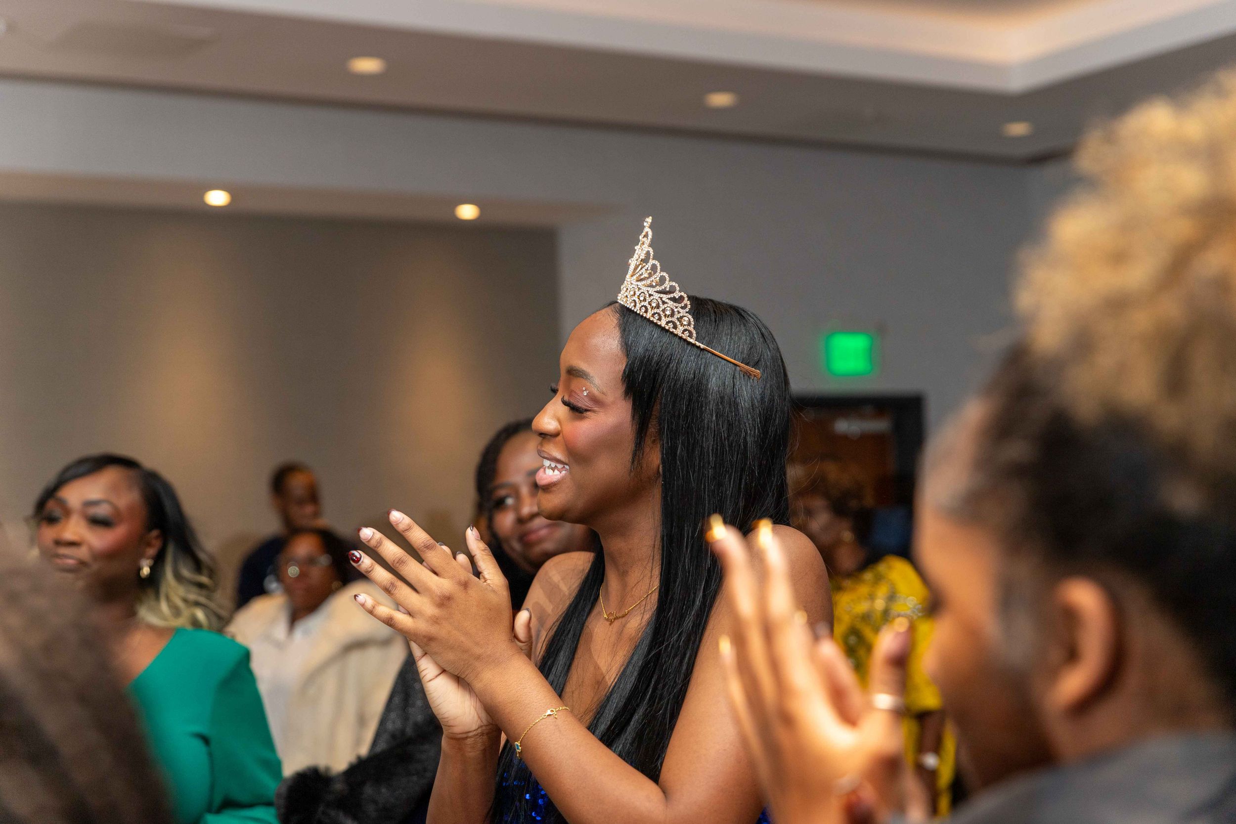 A celebration in a grey room with people clapping and wearing formal attire.