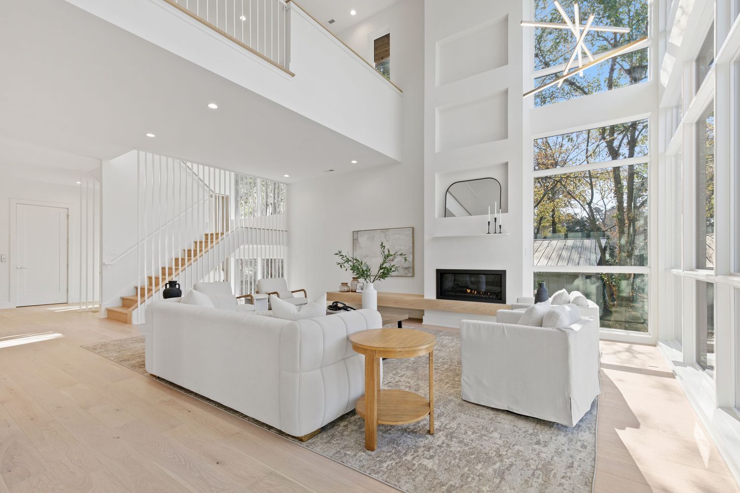 Bright coastal living room with built-in shelves, fireplace and neutral furnishings.