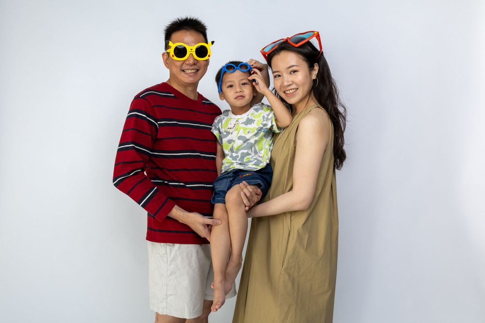 A casual family portrait with bright accessories against a white background.